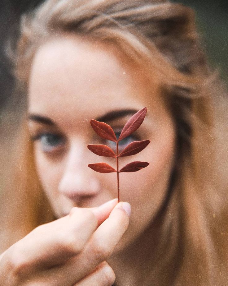 a woman holding a small plant in her hand