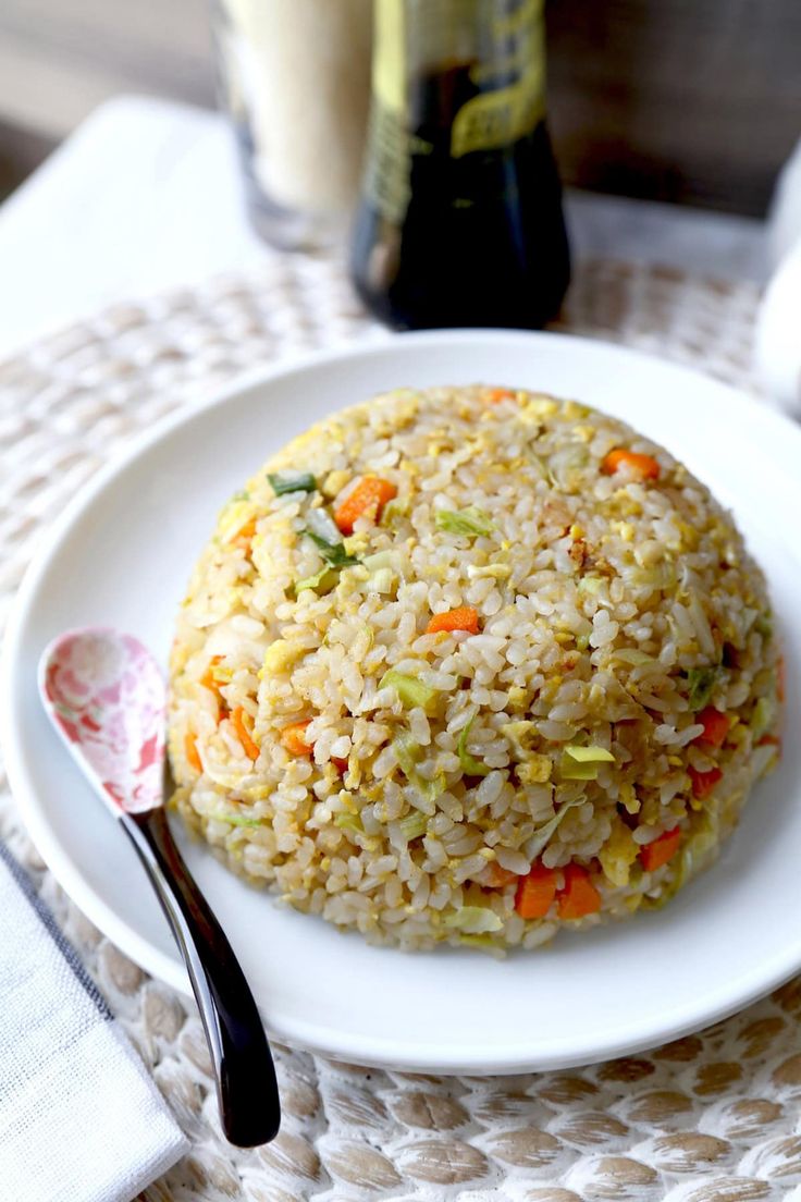 a white plate topped with rice and veggies next to a bottle of milk