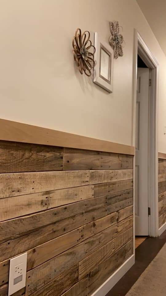 a hallway with wood paneling and pictures on the wall