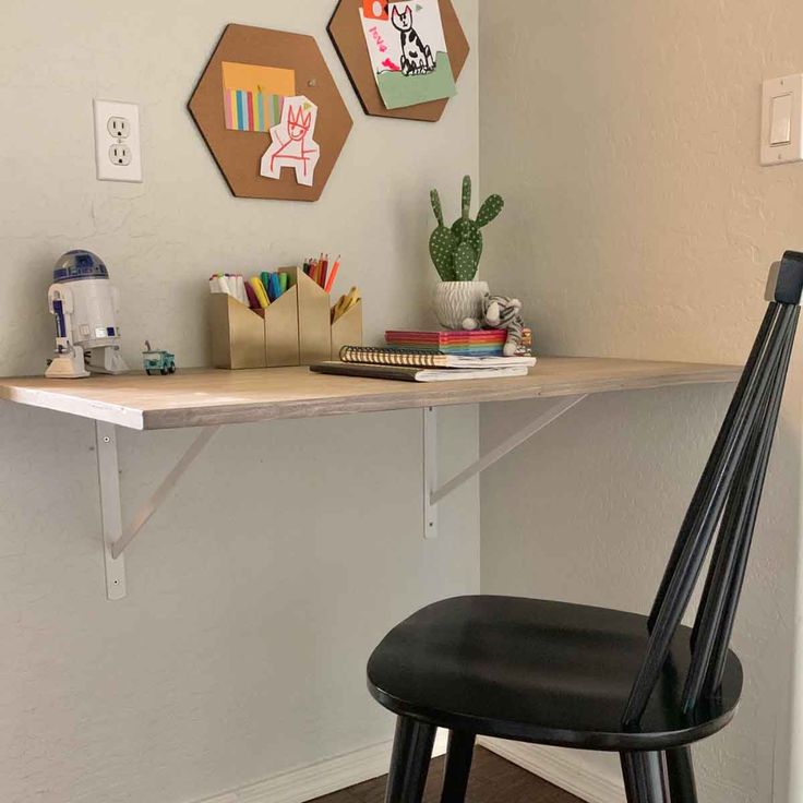 a black chair sitting in front of a desk with two hexagonals on it