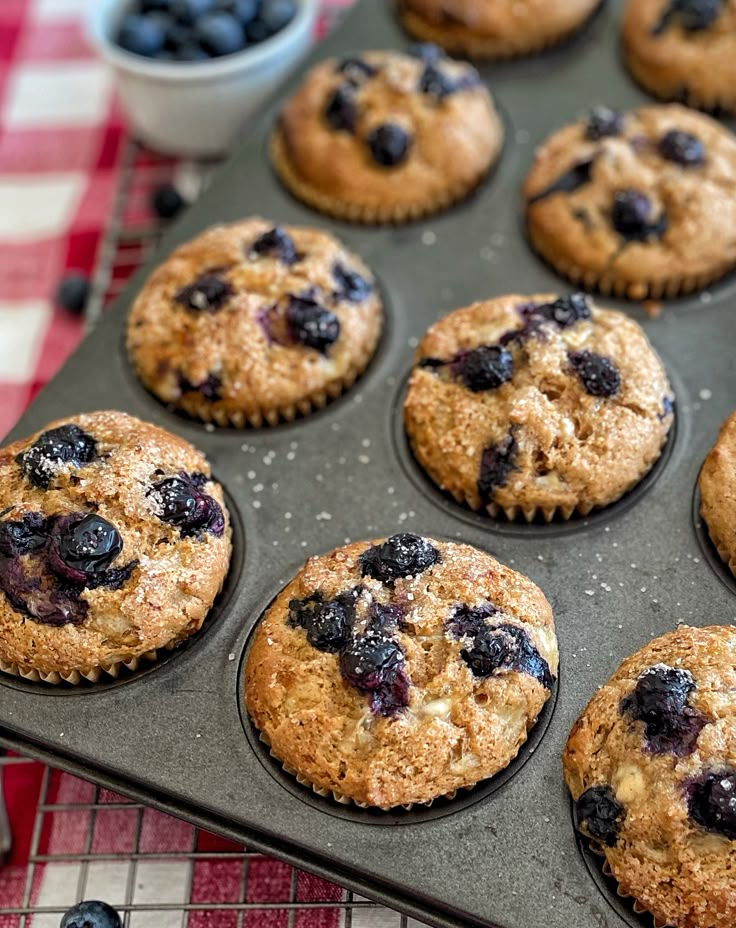 blueberry muffins in a baking pan on a red and white checkered tablecloth