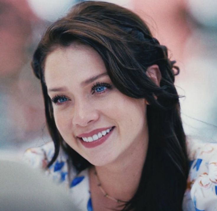 a close up of a woman smiling at the camera