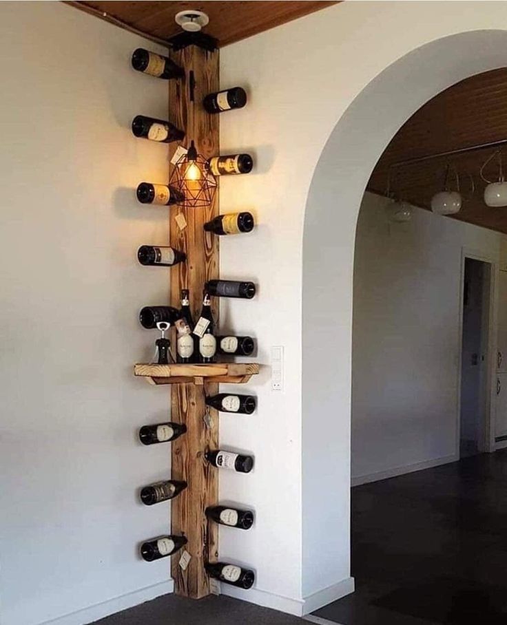 a wine rack made out of wooden planks with bottles on it and lights hanging from the ceiling