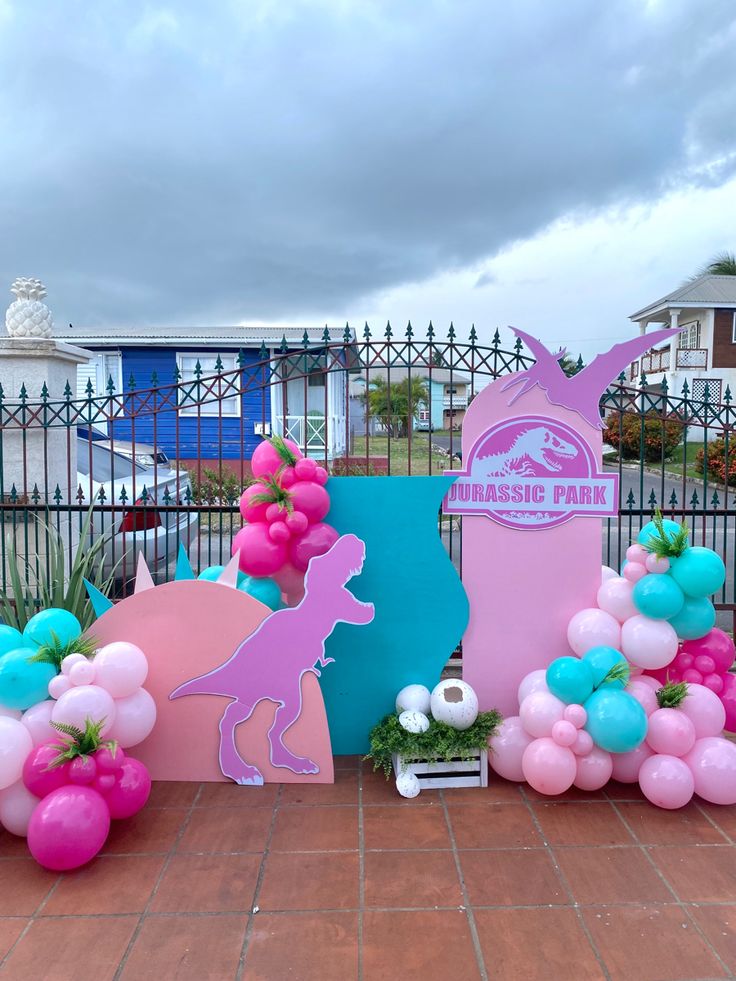 there are balloons and decorations on the ground near some fenced in area with a sign