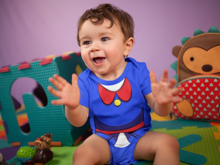 a baby sitting on the floor with his hands out