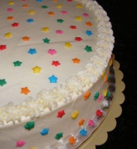 a cake with white frosting and multicolored stars on it