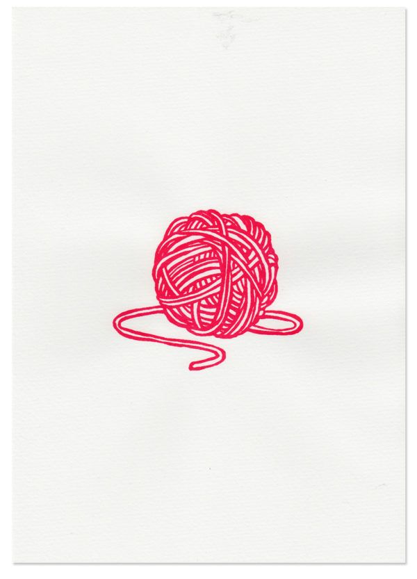 a red ball of yarn sitting on top of a white sheet