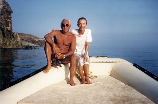 two people sitting on the back of a boat