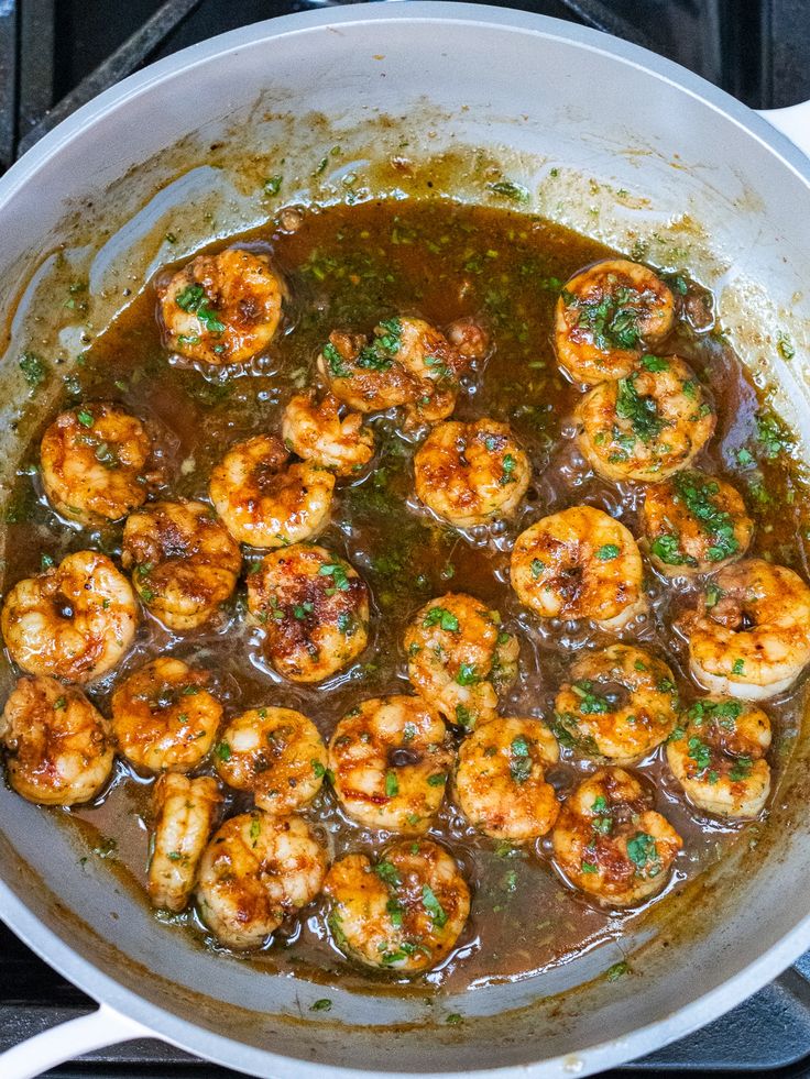 cooked shrimp with sauce and parsley in a pan on the stove top, ready to be eaten