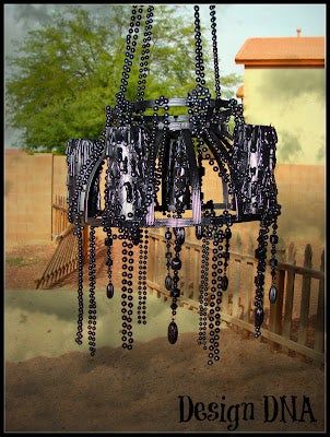 a chandelier hanging from the ceiling in front of a fence with trees behind it