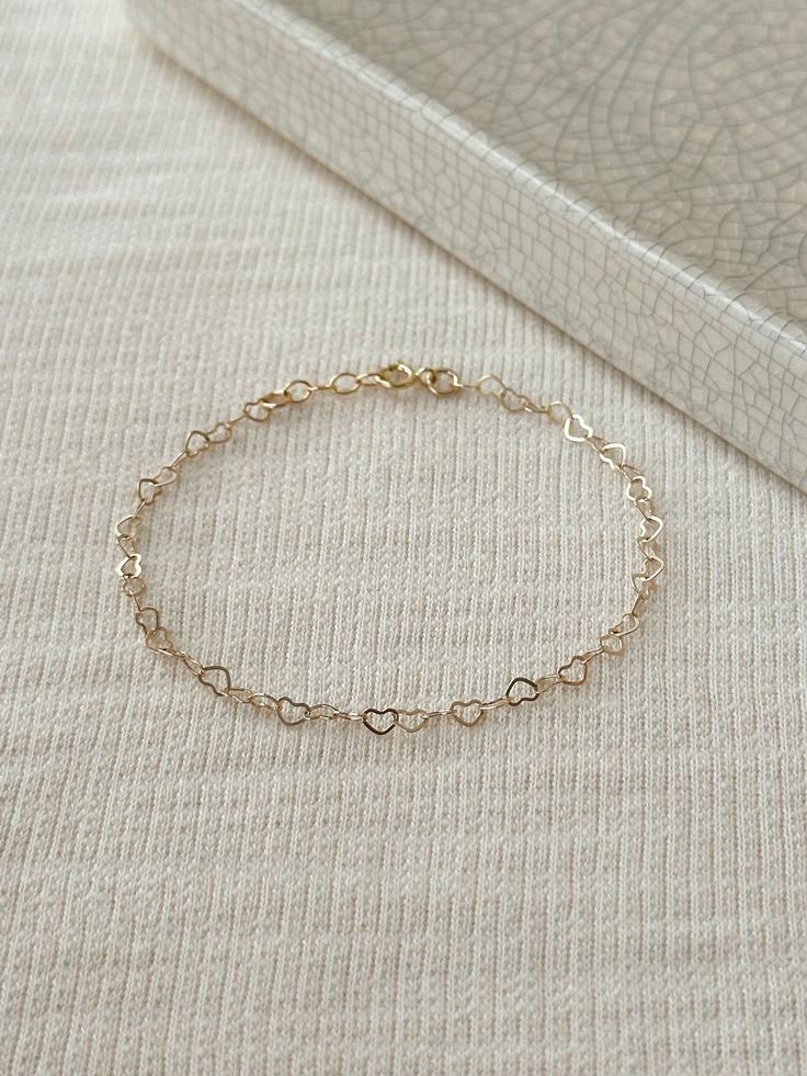 "Hearts are melting for this dainty yet durable mini heart chain bracelet! 💛 This unique chain is sensitive skin and water safe, and is made to live your life in! Wear this minimal piece to brunch, or on a date... this simple heart chain looks lovely anywhere you take it! Details: * 3.5mm 14K Gold Filled heart chain * Dainty 14K Gold Filled spring clasp * 14/20 gf stamp for authenticity * Choose your length (each bracelet comes with a .5\" extender chain for adjustable sizing.) * Made with all Simple Chain Bracelet, Adjustable Heart-shaped Delicate Chain Bracelet, Delicate Heart Bracelet With Chain For Everyday Wear, Delicate Heart Bracelet With Delicate Chain For Everyday, Dainty Heart Bracelet With Adjustable Chain, Adjustable Delicate Heart-shaped Chain Bracelet, Adjustable Delicate Heart Chain Bracelet, Adjustable Delicate Heart Shaped Chain Bracelet, Dainty Bracelets With Adjustable Chain For Valentine's Day