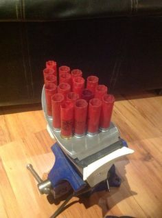 many red candles are lined up on a small machine that is sitting on the floor