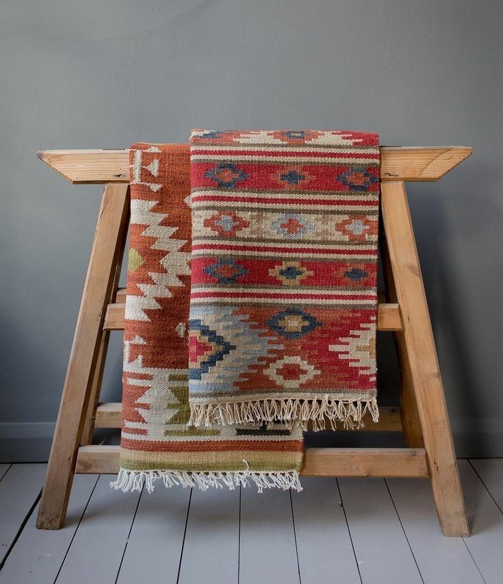 a wooden chair with a multicolored rug on it's back and legs