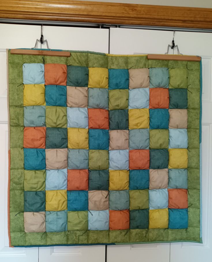 a quilt hanging on the wall in front of a door