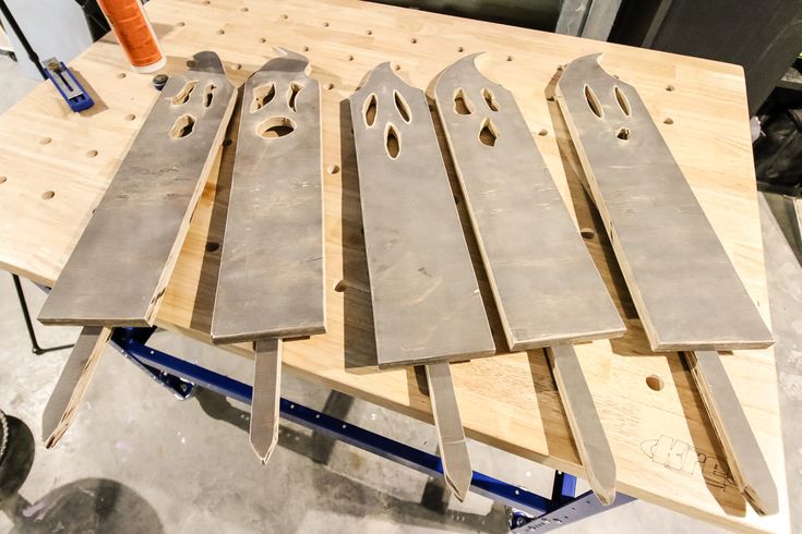 five knives are sitting on top of some wood planks in the process of being made