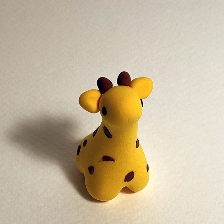 a toy giraffe sitting on top of a white table