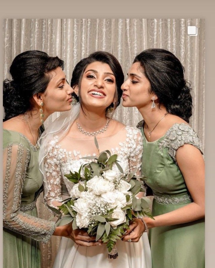 three women in green dresses standing next to each other and one is holding a bouquet