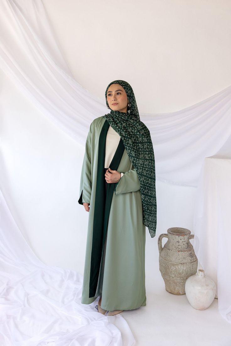 A timeless silhouette with drape and a green two-tone versatility, this abaya will have you feeling effortlessly elegant for your Eid celebrations. Reversible in nature, this abaya can be dressed in two ways to showcase different styles effortlessly. Crafted from high-quality, breathable fabric, this versatile abaya ensures comfort and durability, making it an essential addition to your wardrobe. Complete the look with our black or beige underdresses or rock it alone. Aisha is seen wearing a S/M Pocket Abaya, Green Brown Palette, Green Abaya, Eid Celebrations, Abaya Black, Green Side, Instant Hijab, Abaya Fashion, Silk Chiffon