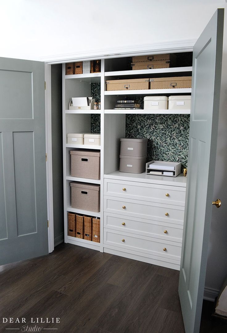 a white bookcase with drawers and baskets on it in a room that is painted gray