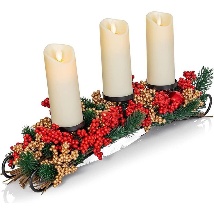 three candles are sitting on a tray with holly and berries