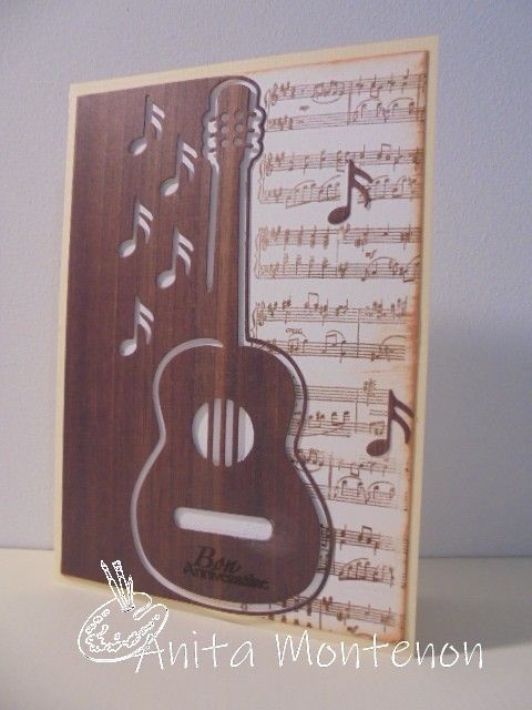 a wooden card with musical notes and an acoustic guitar in the middle, on a table