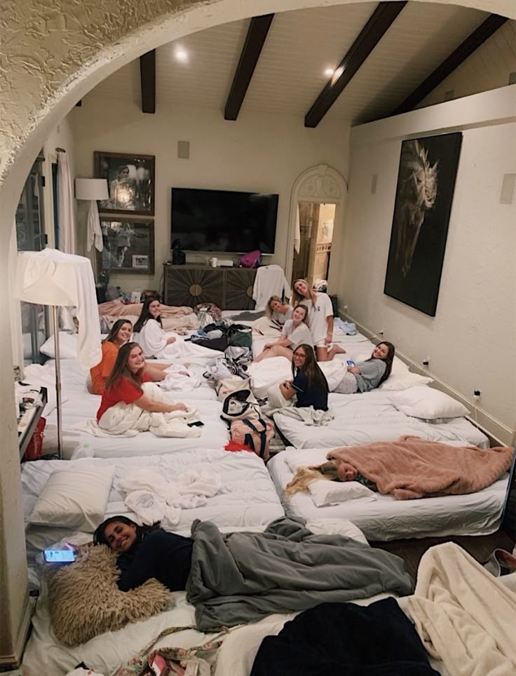 a group of people laying on top of beds in a room