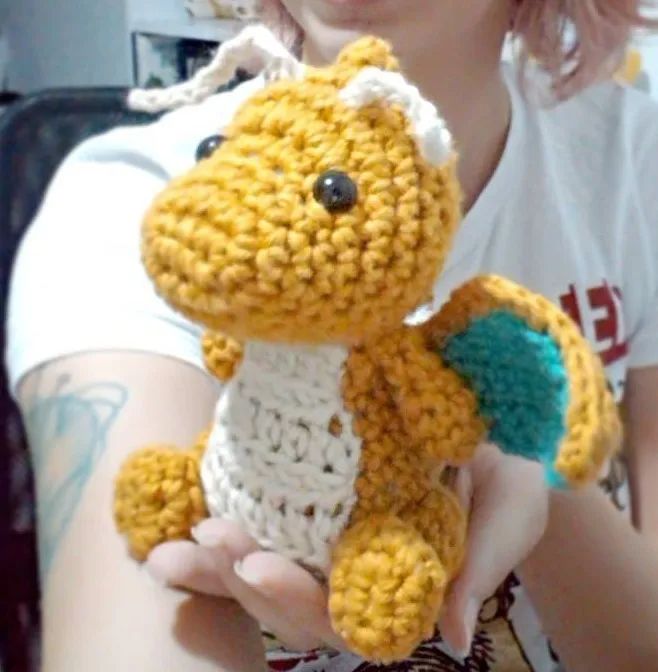 a woman holding a crocheted stuffed animal in her hands