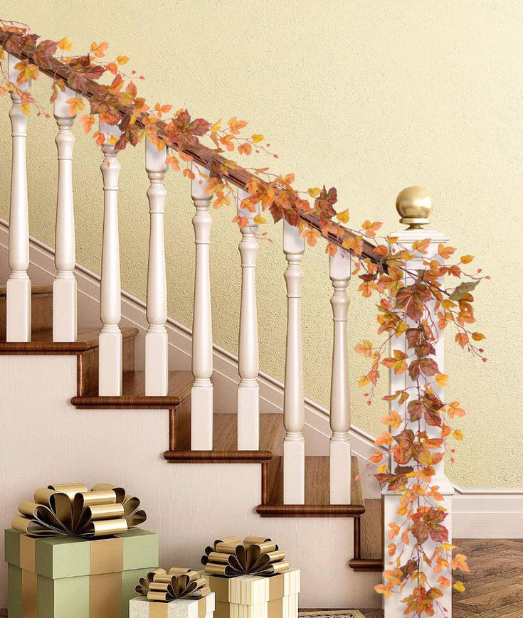 the stairs are decorated with fall leaves and ribbons, along with gift boxes under them