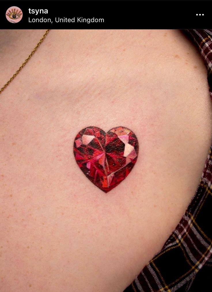 a red heart tattoo on the back of a woman's chest