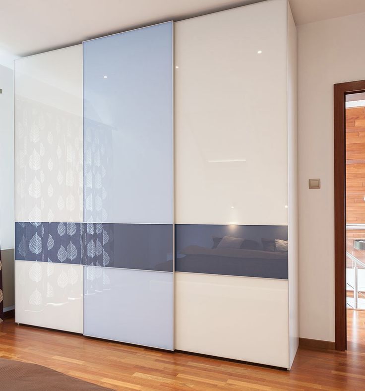 a bedroom with white and blue sliding doors in it's center area, next to a wooden floor