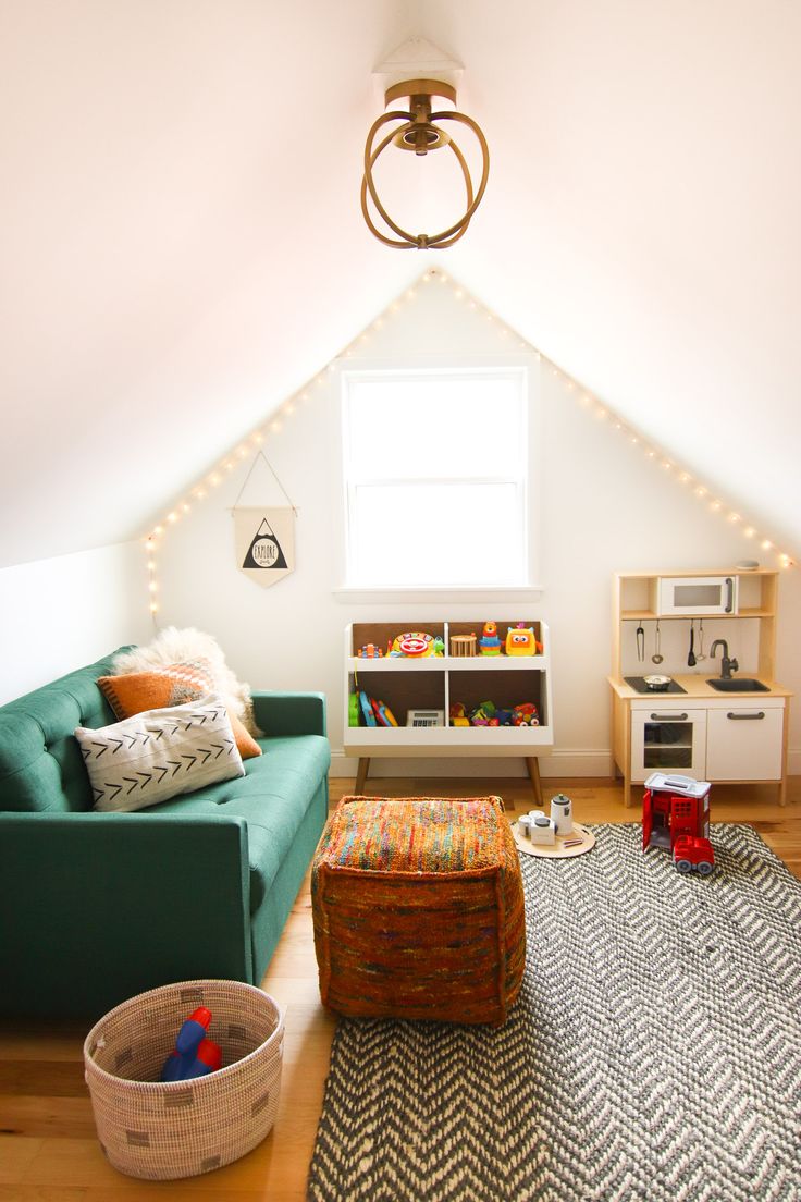 a living room filled with furniture and a small kitchen in the back drop down ceiling