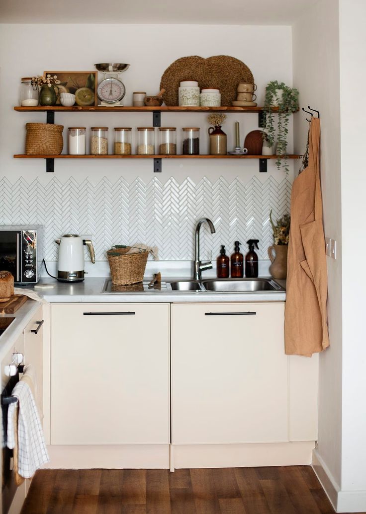 a kitchen with white cabinets and shelves filled with dishes