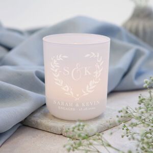 a white candle sitting on top of a table next to some flowers and blue cloth