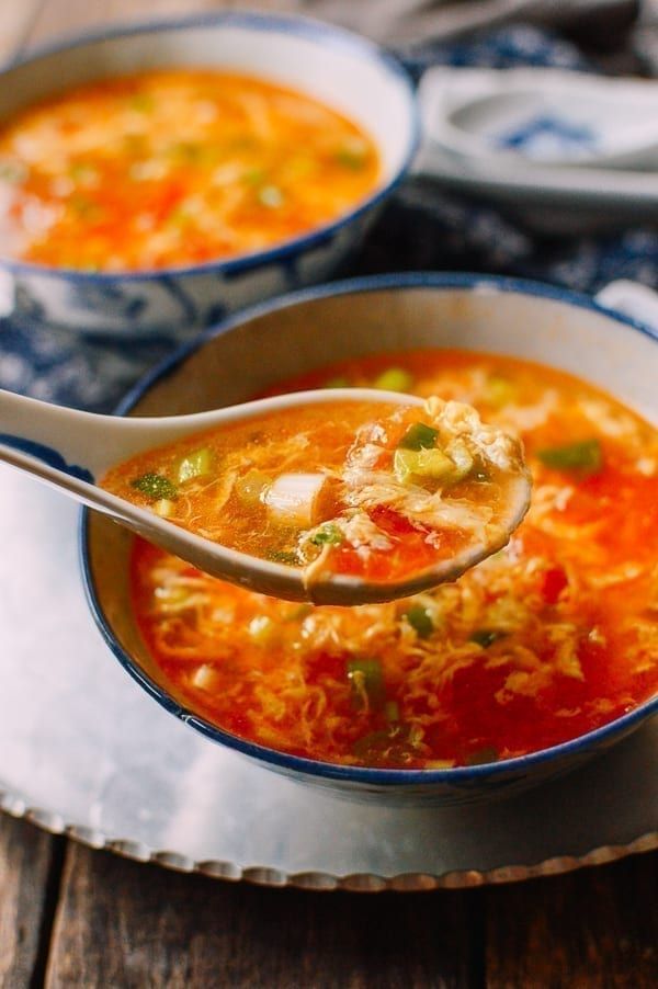 two bowls of soup with spoons in them