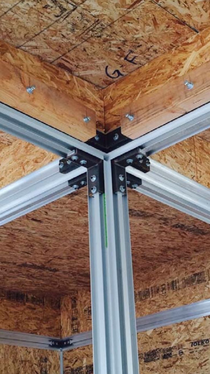 the inside of a building with metal framing and wood panels on the ceiling is shown