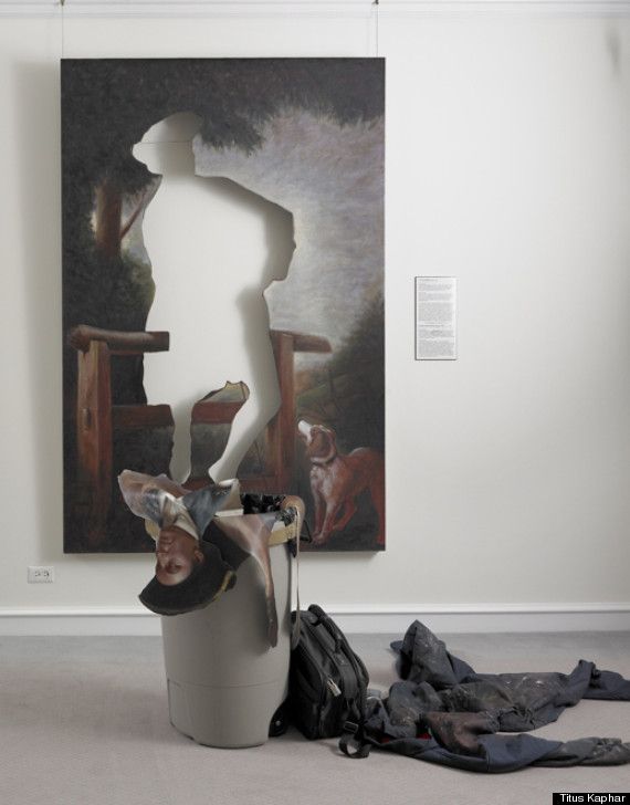 a white mannequin standing on top of a trash can in front of a painting