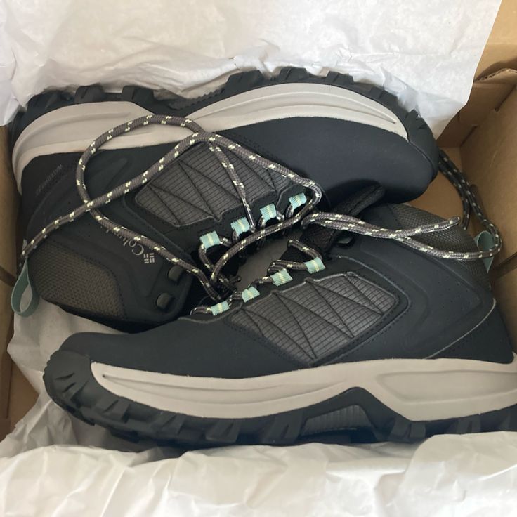 a pair of shoes in a box with chains on the soles and one shoelace