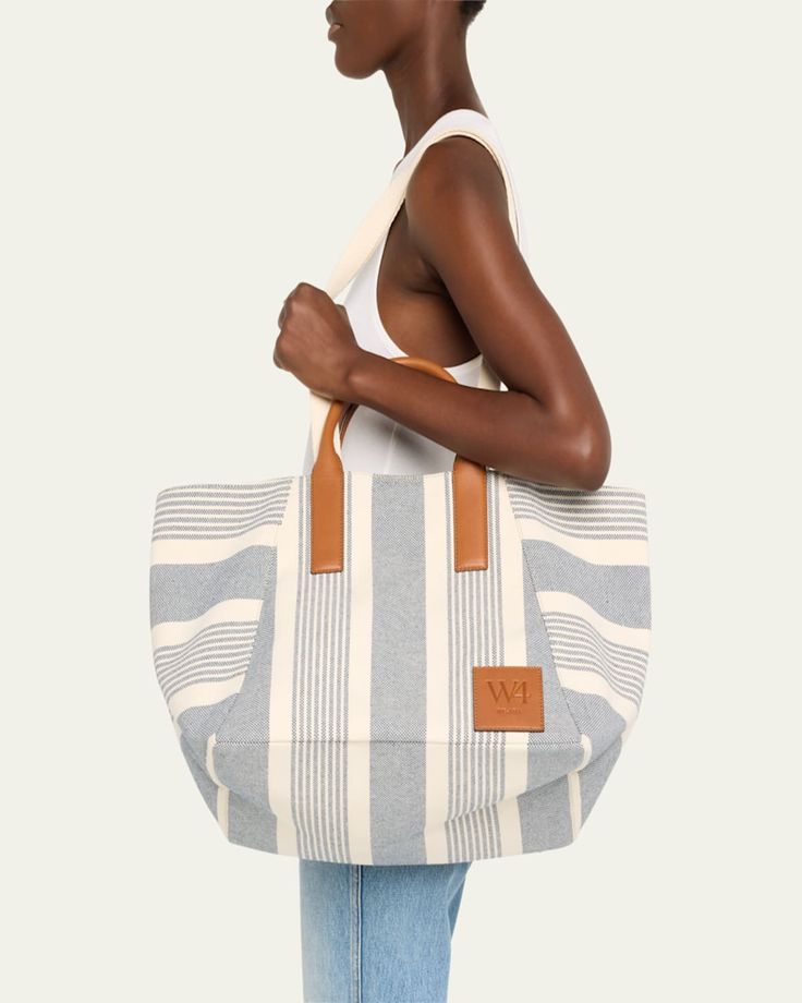 WEAR4 "The Riviera" tote bag in striped canvas cotton     Top handles     Detachable, adjustable shoulder strap, 15.5"L    Can be worn as a top handle or shoulder bag     Open top with snap closure     Approx. 12"H x 22"W x 11"D    Imported Striped Top Handle Bag For Everyday Use, Striped Top Handle Bag For Shopping, Striped Bag With Leather Handles For Everyday Use, Travel Tote Shoulder Bag With Striped Lining, Modern Striped Tote Bag, Everyday Striped Bags With Leather Handles, Canvas Bags With Striped Lining For Everyday Use, Striped Travel Tote Shoulder Bag, Striped Tote Shoulder Bag For Travel