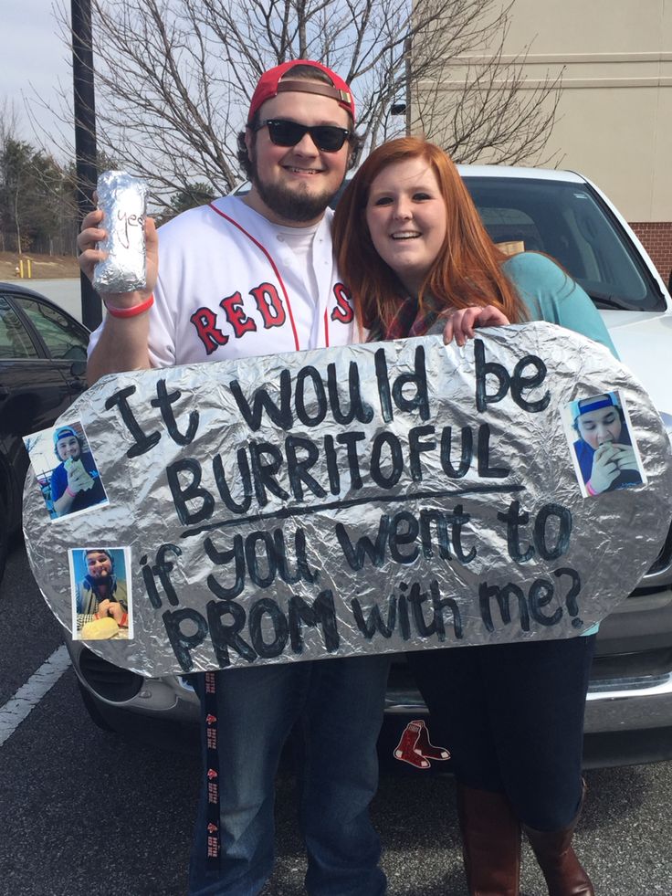 a man and woman standing next to each other in front of a car holding a sign that says it would be burrito if you went from with me?