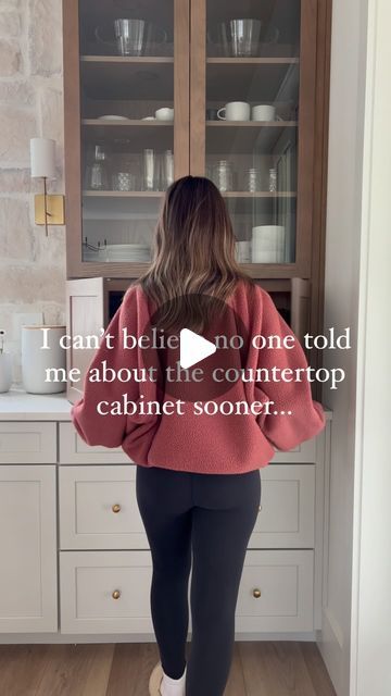 a woman standing in front of a kitchen counter with the words i can't believe no one told me about the countertop cabinet soon