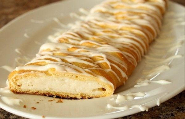 a white plate topped with a pastry covered in icing