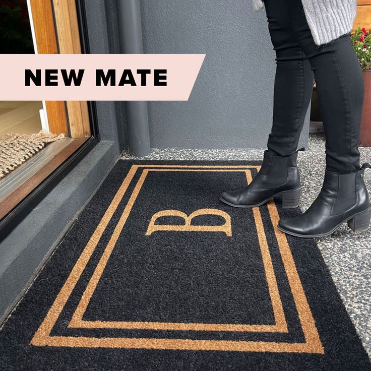 a woman standing in front of a door with her feet on the mat that says new mate