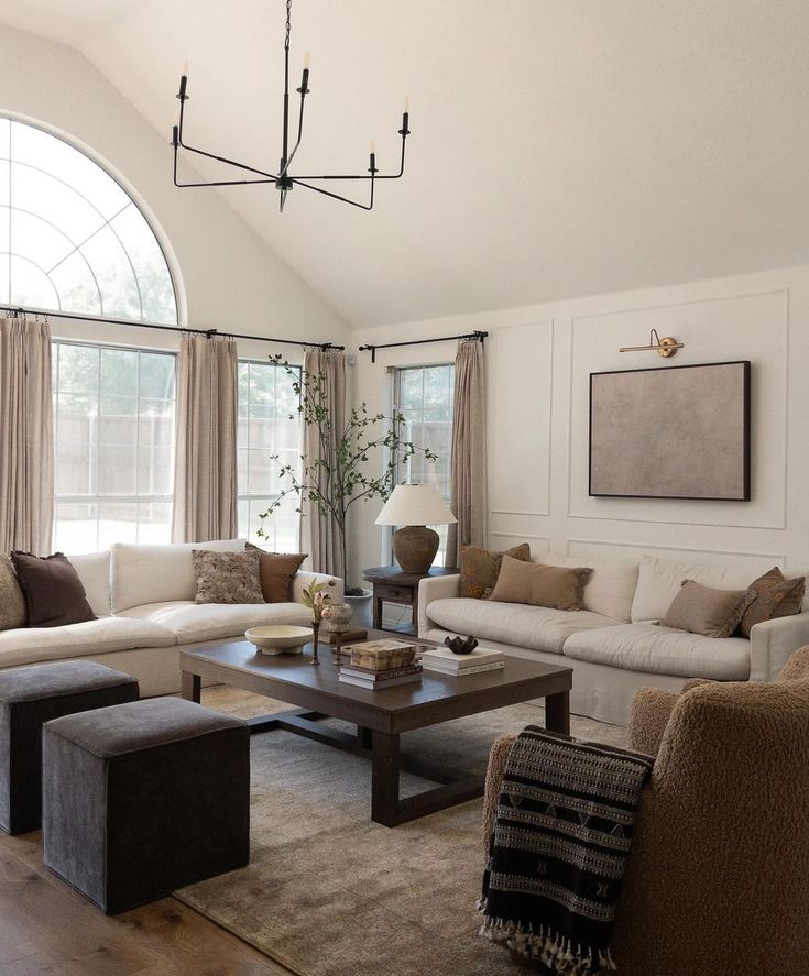 a living room filled with lots of furniture next to a large arched window in the wall