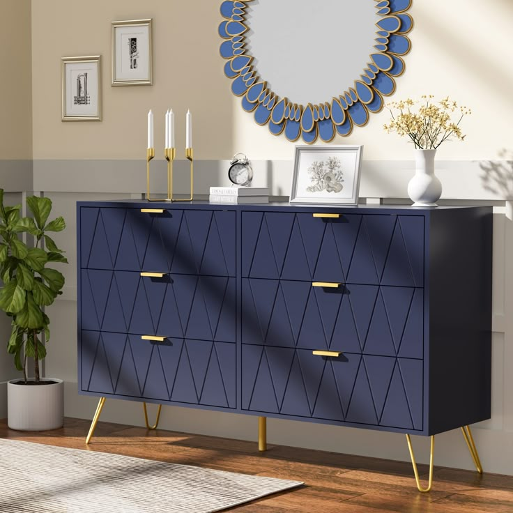 a blue and gold dresser in a living room with a mirror on the wall above it