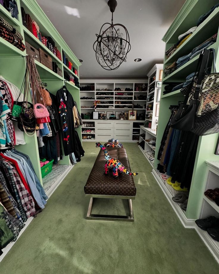 a walk in closet with green walls and shelves