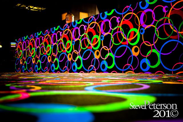 colorful circles are projected on the floor in front of a wall