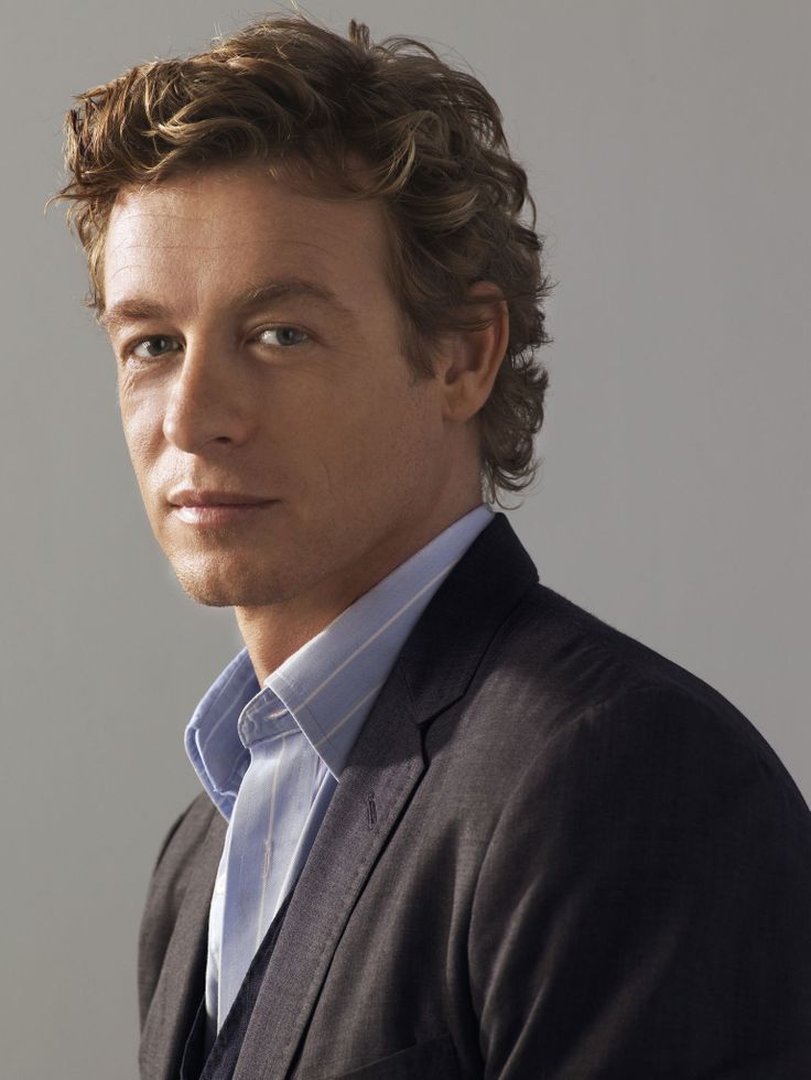 a man with curly hair wearing a suit and tie