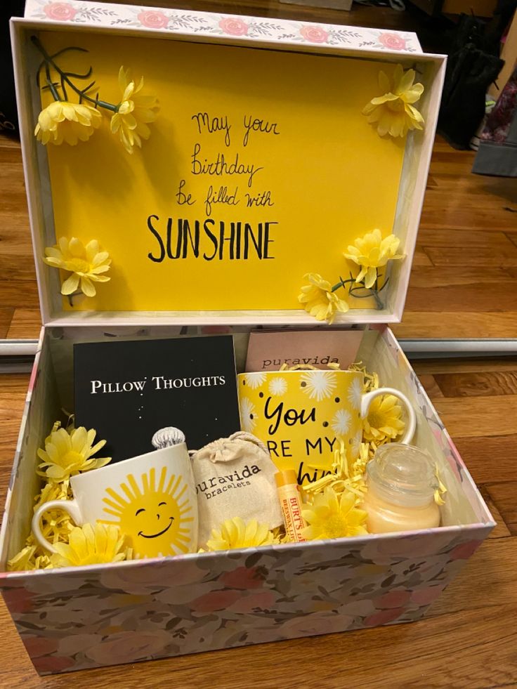 an open box with yellow flowers and cards inside