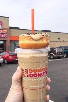 a dunkin donuts coffee drink in front of a dunkin donuts store