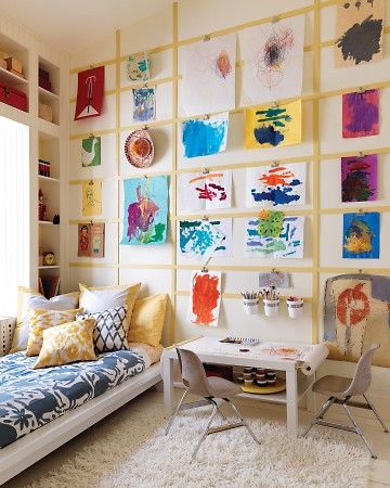 a living room filled with furniture and paintings on the wall behind a white table topped with two chairs